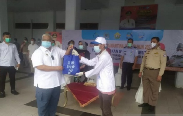Gubernur Sultra Ali Mazi saat menyerahkan bantuan ikan segar dari BKIPM secara simbolis kepada salah satu warga terdampak COVID-19 di Kendari