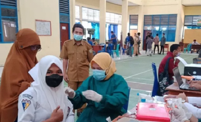 Kepala SMKN 2 Baubau, Muhammad Fahirin Sjafei (ketiga kiri) menyaksikan vaksinasi terhadap pelajar di sekolah itu